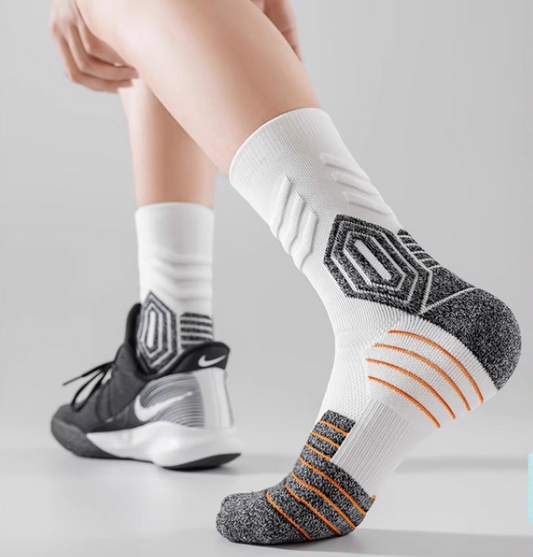 White socks with black and orange patterns worn with black Nike sneakers on a light gray background