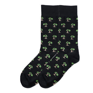 A pair of black socks with a green and brown tree pattern.